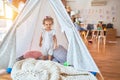 Beautiful caucasian infant playing with toys at colorful playroom