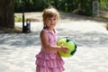 Beautiful caucasian little girl with a big ball on the playing field. Royalty Free Stock Photo