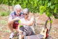 Beautiful caucasian mature couple man and woman do soap bubbles together to play and have fun with joy, outdoor nature location Royalty Free Stock Photo