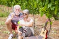 Beautiful caucasian mature couple man and woman do soap bubbles together to play and have fun with joy, outdoor nature location Royalty Free Stock Photo