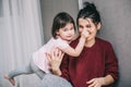 Beautiful Caucasian mother and her child playing together at home. Girl and mom in casual sitting on th carpet. Happy mum and kid Royalty Free Stock Photo