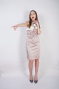 Beautiful caucasian teen girl stands in a short evening dress and mocks the interlocutor, humiliating, on a white background in th Royalty Free Stock Photo