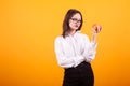 Beautiful caucasian teenage girl holding and looking at a red apple in studio over yellow background Royalty Free Stock Photo