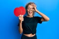 Beautiful caucasian teenager girl holding red ping pong rackets smiling happy doing ok sign with hand on eye looking through