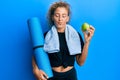 Beautiful caucasian teenager girl holding yoga mat and green apple looking at the camera blowing a kiss being lovely and sexy Royalty Free Stock Photo