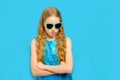 Beautiful Caucasian teenager girl looks angrily. The girl is dressed in a beautiful blue dress and sunglasses. Isolated Royalty Free Stock Photo