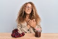 Beautiful caucasian teenager girl making grape jam smiling with hands on chest, eyes closed with grateful gesture on face