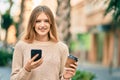 Beautiful caucasian teenager using smartphone drinking coffee at the city Royalty Free Stock Photo