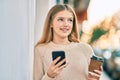 Beautiful caucasian teenager using smartphone and drinking coffee at the city Royalty Free Stock Photo