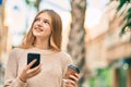 Beautiful caucasian teenager using smartphone drinking coffee at the city Royalty Free Stock Photo