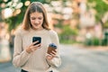 Beautiful caucasian teenager using smartphone and drinking coffee at the city Royalty Free Stock Photo