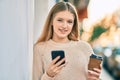 Beautiful caucasian teenager using smartphone and drinking coffee at the city Royalty Free Stock Photo