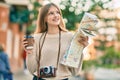 Beautiful caucasian tourist teenager drinking coffee holding map at the city