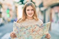 Beautiful caucasian tourist teenager smiling happy holding map at the city
