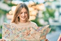 Beautiful caucasian tourist teenager smiling happy holding map at the city