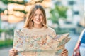 Beautiful caucasian tourist teenager smiling happy holding map at the city