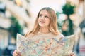 Beautiful caucasian tourist teenager smiling happy holding map at the city