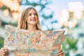 Beautiful caucasian tourist teenager smiling happy holding map at the city