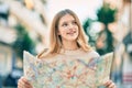 Beautiful caucasian tourist teenager smiling happy holding map at the city