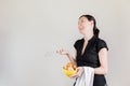 Beautiful Caucasian woman with black shirt holding an eggbeater and a yellow bowl full of chicken eggs