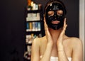 Beautiful caucasian woman with black silicone mask for the skin. Pretty brunette female with cosmetic mask on her face Royalty Free Stock Photo