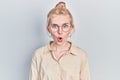 Beautiful caucasian woman with blond hair wearing casual look and glasses afraid and shocked with surprise expression, fear and Royalty Free Stock Photo