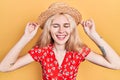 Beautiful caucasian woman with blond hair wearing summer hat smiling and laughing hard out loud because funny crazy joke Royalty Free Stock Photo