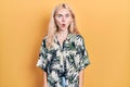 Beautiful caucasian woman with blond hair wearing tropical shirt afraid and shocked with surprise expression, fear and excited Royalty Free Stock Photo