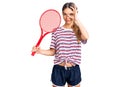 Beautiful caucasian woman with blonde hair playing tennis holding racket smiling happy doing ok sign with hand on eye looking Royalty Free Stock Photo