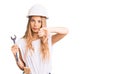 Beautiful caucasian woman with blonde hair wearing hardhat and builder clothes with angry face, negative sign showing dislike with Royalty Free Stock Photo