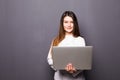 Beautiful Caucasian woman doctor or nurse holding a laptop computer isolated on a grey background Royalty Free Stock Photo