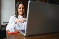 Beautiful Caucasian woman dreaming about something while sitting with portable net-book in modern cafe bar, young charming female Royalty Free Stock Photo