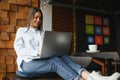 Beautiful Caucasian woman dreaming about something while sitting with portable net-book in modern cafe bar, young charming female Royalty Free Stock Photo