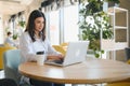 Beautiful Caucasian woman dreaming about something while sitting with portable net-book in modern cafe bar, young Royalty Free Stock Photo