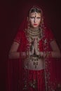 Beautiful caucasian woman dressed in Indian bridal Sari along with specific jewelry: Mangalsutra, Thaali, Maang Tikka, Choora, Nat