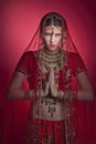 Beautiful caucasian woman dressed in Indian bridal Sari along with specific jewelry: Mangalsutra, Thaali, Maang Tikka, Choora, Nat