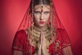 Beautiful caucasian woman dressed in Indian bridal Sari along with specific jewelry: Mangalsutra, Thaali, Maang Tikka, Choora, Nat