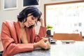 Beautiful Caucasian woman drinking coffee in cafe restaurant alone. The girl holding cup of hot coffee sitting on table next to wi Royalty Free Stock Photo