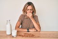 Beautiful caucasian woman drinking healthy almond milk feeling unwell and coughing as symptom for cold or bronchitis Royalty Free Stock Photo