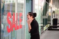 Beautiful caucasian woman excited when see the price tag on sale clothing fashion at the store Royalty Free Stock Photo