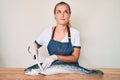 Beautiful caucasian woman fishmonger selling fresh raw salmon smiling looking to the side and staring away thinking