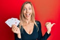 Beautiful caucasian woman holding ace poker cards pointing thumb up to the side smiling happy with open mouth