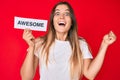 Beautiful caucasian woman holding awesome banner screaming proud, celebrating victory and success very excited with raised arms