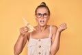 Beautiful caucasian woman holding a piece of emmental cheese annoyed and frustrated shouting with anger, yelling crazy with anger