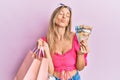 Beautiful caucasian woman holding shopping bags and canadian dollars looking at the camera blowing a kiss being lovely and sexy Royalty Free Stock Photo