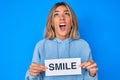 Beautiful caucasian woman holding smile text angry and mad screaming frustrated and furious, shouting with anger looking up