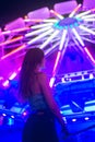 Beautiful Caucasian woman with long hair standing in front of the Ferris wheel with lights at night Royalty Free Stock Photo