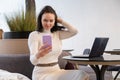 Beautiful caucasian woman makes selfie on a smartphone sitting at a table with a laptop. a blogger creates content, a blog author