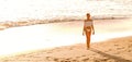 Beautiful caucasian woman ona  relaxing walk on empty beach at sunset sea shore Royalty Free Stock Photo