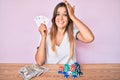 Beautiful caucasian woman playing poker holding cards stressed and frustrated with hand on head, surprised and angry face Royalty Free Stock Photo